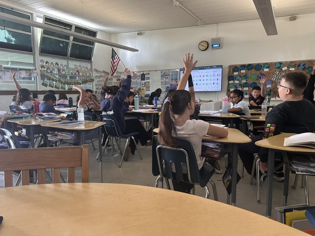 Elementary Teacher Education practicum classroom with students raising their hands